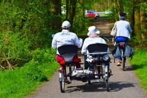 Home Twee personen rijden samen op een duofiets met twee sets pedalen en sturen voor optimalale training.