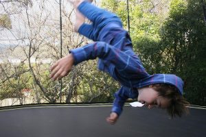 Home Gezin springend op trampoline, illustratief voor de geheimen van buitenactiviteiten en trampolinespringen